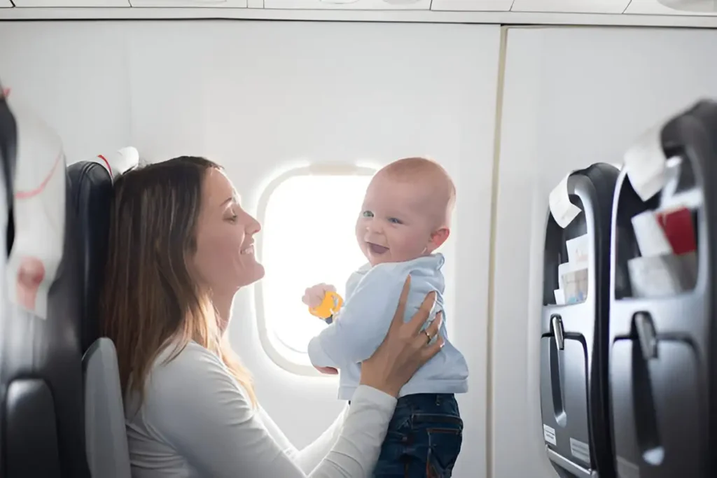 Young mom, playing and breastfeeding her toddler boy on board of aircraft